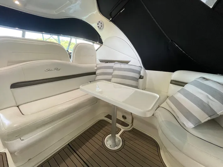  Yacht Photos Pics Interior seating area of 2007 Sea Ray 38 Sundancer with white leather and striped pillows.