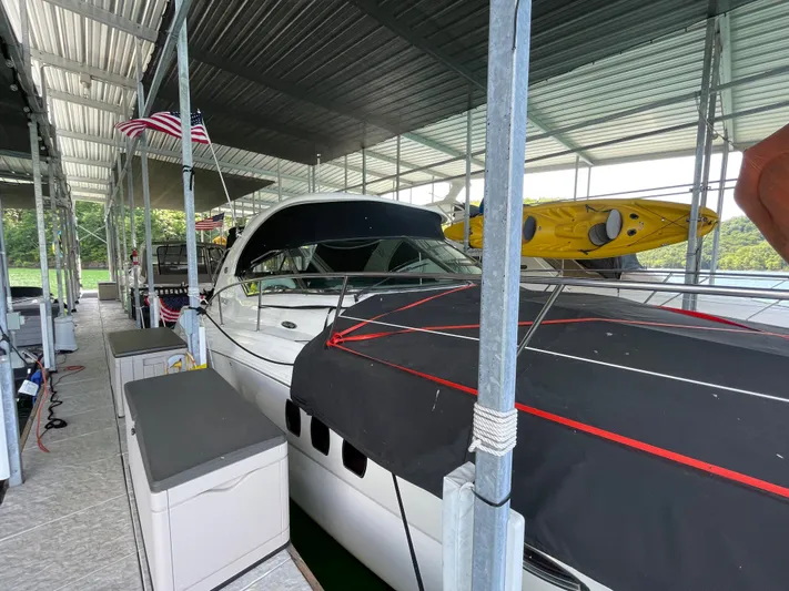  Yacht Photos Pics 2007 Sea Ray 38 Sundancer docked under covered marina with kayaks on top.