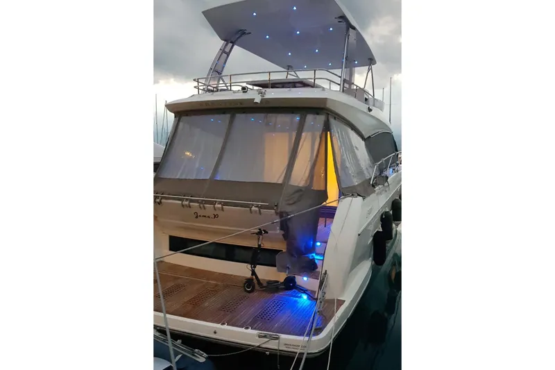  Yacht Photos Pics 2016 Prestige 550 yacht with illuminated deck and canopy at dusk.