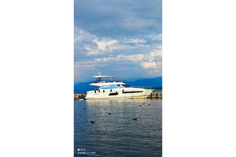  Yacht Photos Pics 2016 Prestige 550 yacht docked on calm water under a cloudy sky.