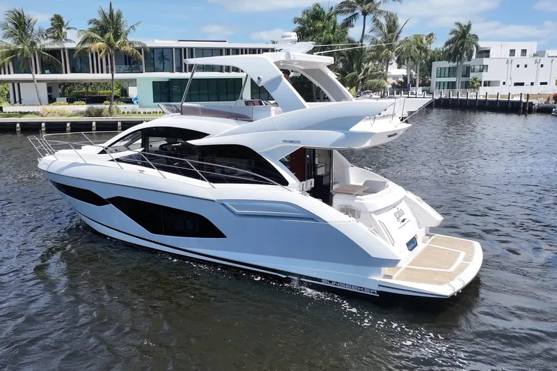 Gaia Yacht Photos Pics 2017 Sunseeker Manhattan 52 yacht cruising near modern waterfront homes.