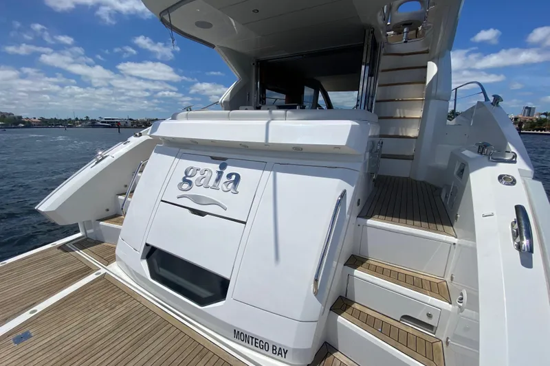 Gaia Yacht Photos Pics 2017 Sunseeker Manhattan 52 yacht, rear view, docked with wooden deck and stairs.