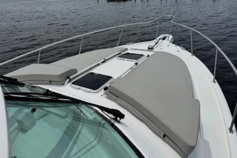Nothing But Fine Yacht Photos Pics 2022 Pursuit OS 385 Offshore boat deck with cushioned seating on calm water.