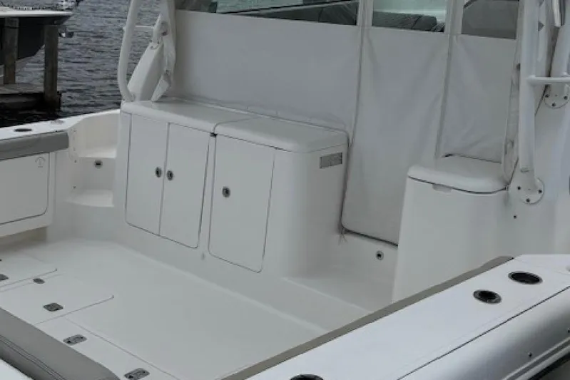 Nothing But Fine Yacht Photos Pics 2022 Pursuit OS 385 Offshore boat interior with storage compartments and seating.