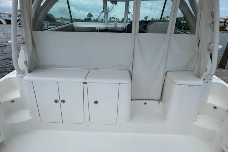 Nothing But Fine Yacht Photos Pics 2022 Pursuit OS 385 Offshore boat interior with white storage compartments.
