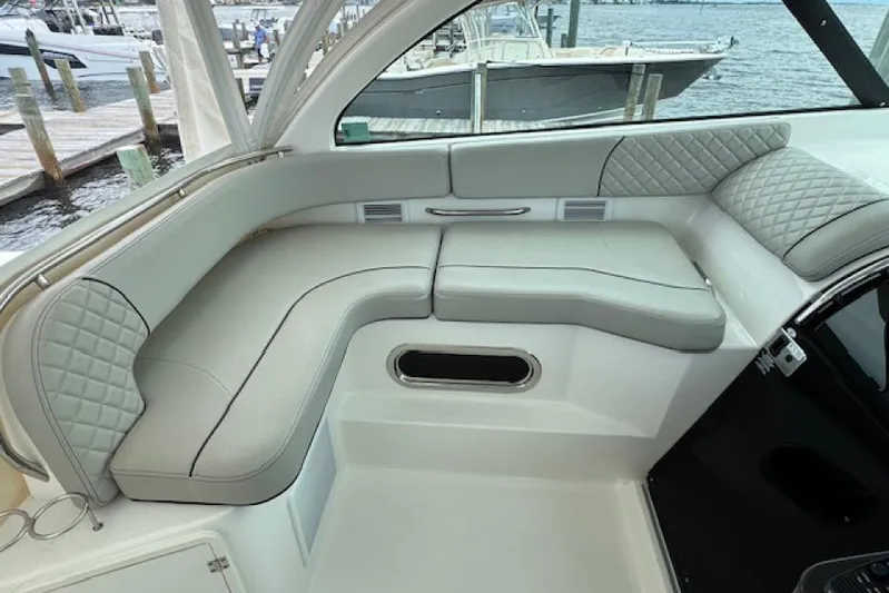 Nothing But Fine Yacht Photos Pics 2022 Pursuit OS 385 Offshore boat interior with cushioned seating and elegant design.