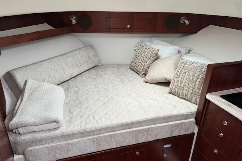 Nothing But Fine Yacht Photos Pics Luxurious cabin interior of 2022 Pursuit OS 385 Offshore boat with cozy bedding.
