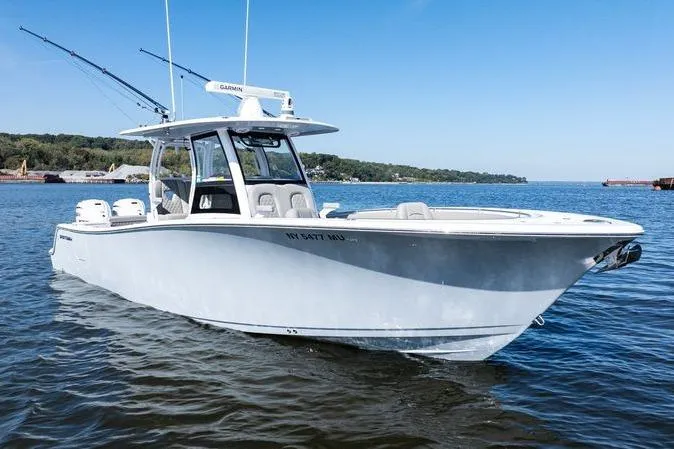  Yacht Photos Pics 2024 Sportsman Open 322 Center Console boat on calm water, clear sky background.