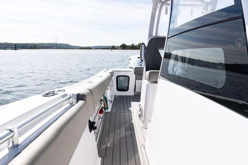  Yacht Photos Pics 2024 Sportsman Open 322 Center Console boat on calm water, showcasing sleek design.