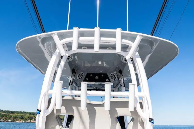  Yacht Photos Pics 2024 Sportsman Open 322 Center Console boat with rod holders and speakers, under clear blue sky.