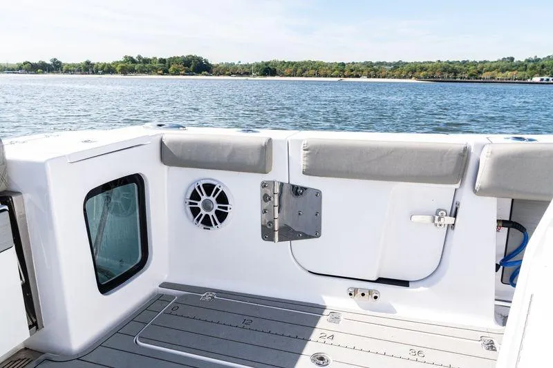  Yacht Photos Pics 2024 Sportsman Open 322 Center Console boat interior with speaker, near scenic shoreline.