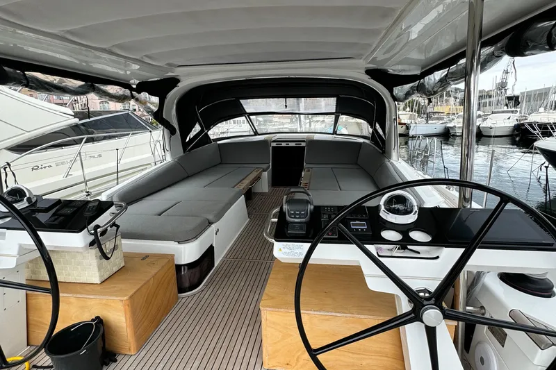  Yacht Photos Pics 2023 Jeanneau 65 Yacht cockpit with modern steering and seating, docked at marina.