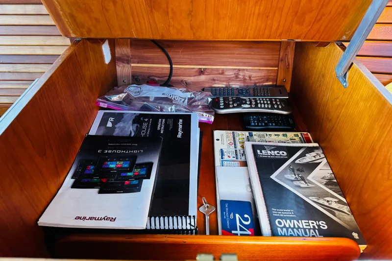 Maverick Yacht Photos Pics Storage compartment in a 2012 Hinckley Picnic Boat MKIII with manuals and remote controls.