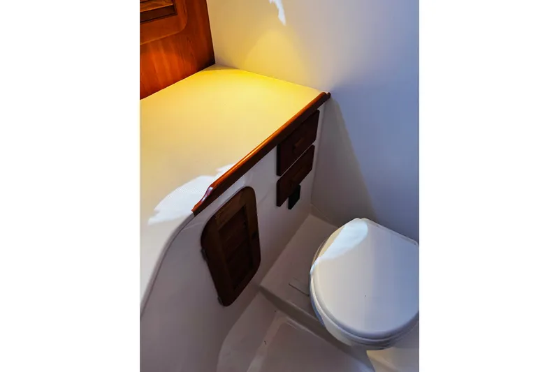 Maverick Yacht Photos Pics 2012 Hinckley Picnic Boat MKIII interior with compact bathroom and wooden cabinetry.