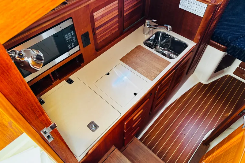 Maverick Yacht Photos Pics Hinckley Picnic Boat MKIII 2012 interior galley with wood cabinetry, sink, and microwave.