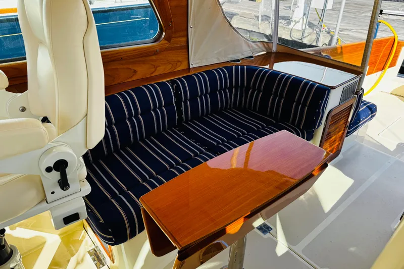 Maverick Yacht Photos Pics Luxurious interior of 2012 Hinckley Picnic Boat MKIII with striped seating and wooden table.