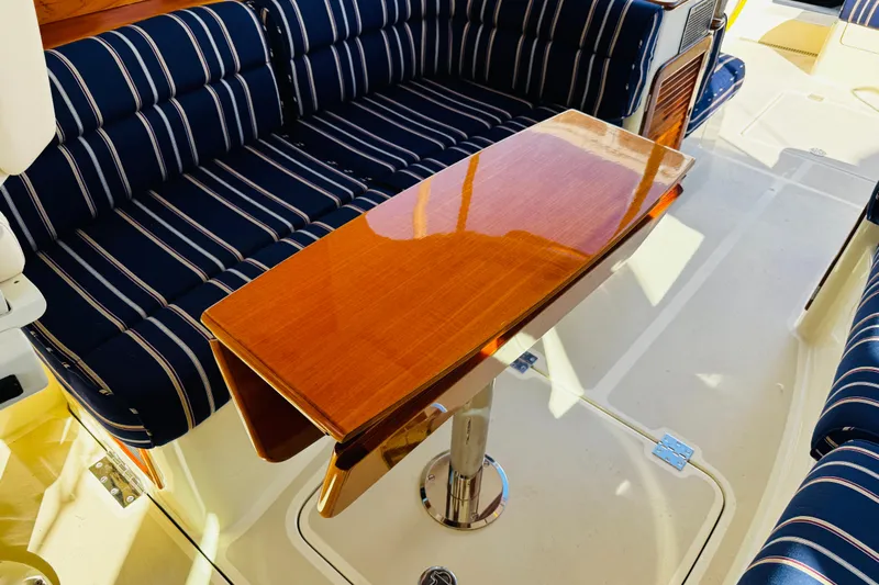 Maverick Yacht Photos Pics Hinckley Picnic Boat MKIII 2012 interior with striped seating and polished wooden table.