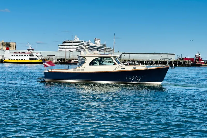 Maverick Yacht Photos Pics 2012 Hinckley Picnic Boat MKIII cruising in a busy harbor with ships in the background.