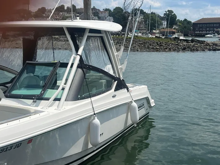  Yacht Photos Pics 2023 Boston Whaler 240 Vantage boat docked in a scenic harbor.