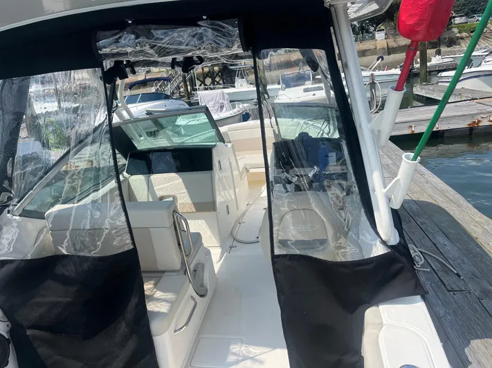  Yacht Photos Pics 2023 Boston Whaler 240 Vantage boat interior at a marina, showcasing seating and helm area.