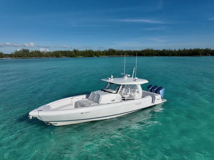  Yacht Photos Pics 2023 Intrepid 427 Nomad SE boat on clear turquoise water, under a blue sky.