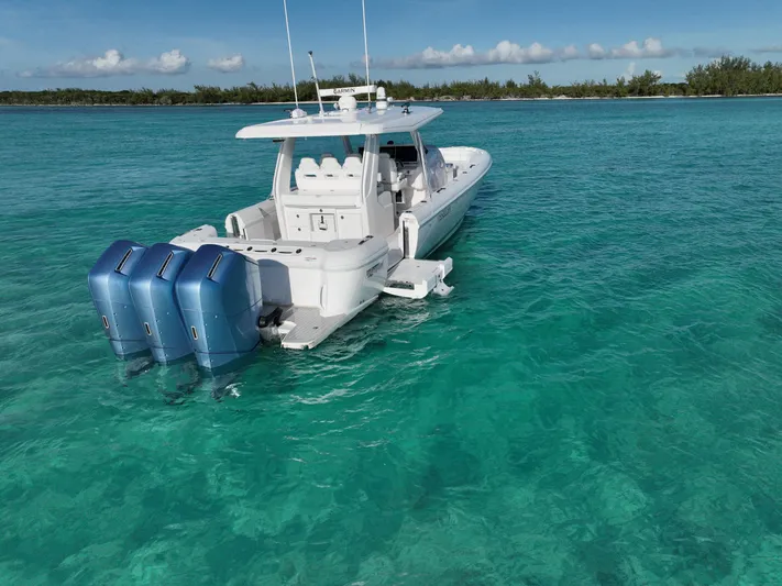  Yacht Photos Pics 2023 Intrepid 427 Nomad SE boat on clear turquoise water, featuring triple outboard engines.