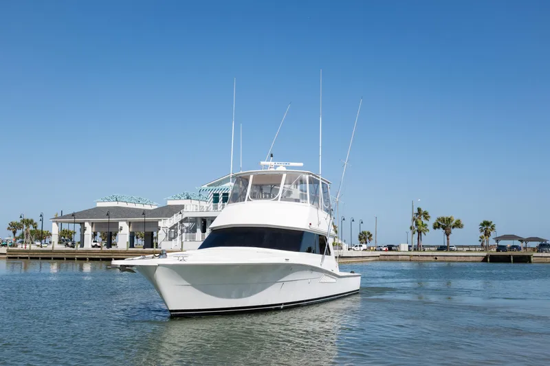  Yacht Photos Pics 1999 Viking 47 Convertible yacht on calm water near a marina.