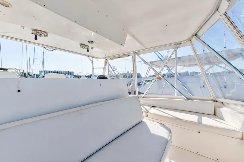  Yacht Photos Pics Interior view of 1999 Viking 47 Convertible yacht with white seating and windows.