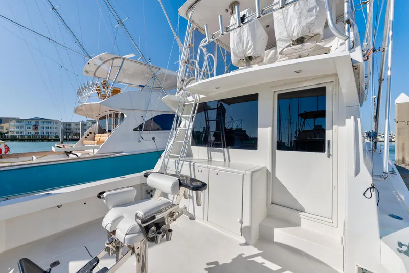  Yacht Photos Pics 1999 Viking 47 Convertible yacht with fishing equipment and ladder, docked in a marina.