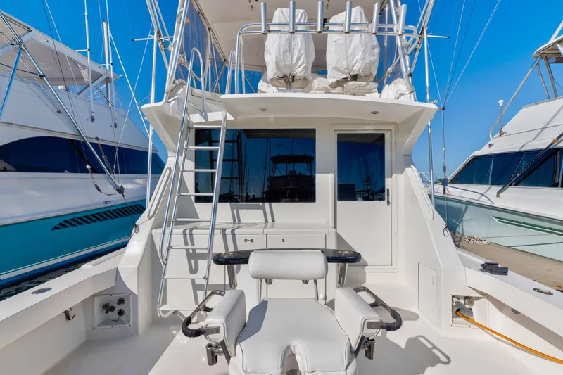 Yacht Photos Pics 1999 Viking 47 Convertible yacht with fishing chair and ladder, docked at marina.