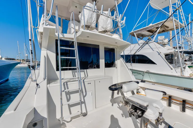 Yacht Photos Pics 1999 Viking 47 Convertible yacht with fishing chair and ladder, docked in a marina.