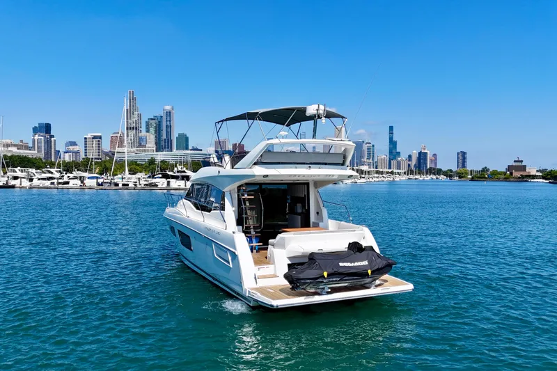  Yacht Photos Pics 2023 Prestige 460 yacht cruising near city skyline on a sunny day.