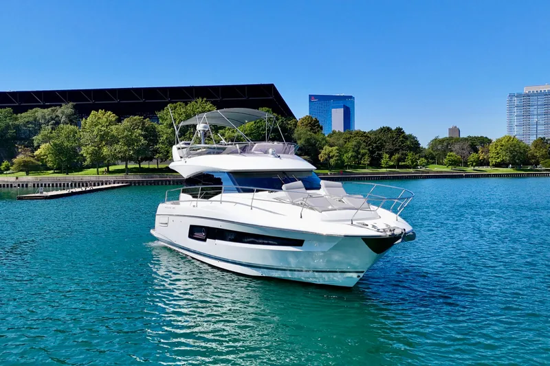  Yacht Photos Pics 2023 Prestige 460 yacht on a serene lake with cityscape background.