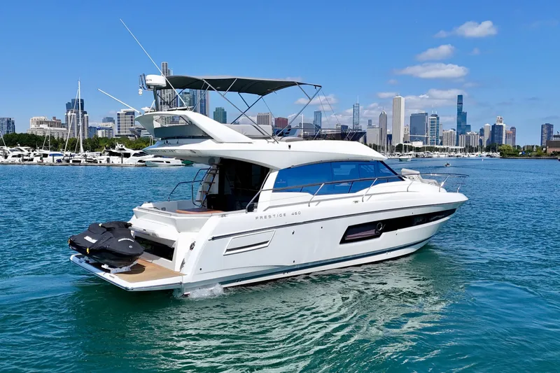  Yacht Photos Pics 2023 Prestige 460 yacht cruising near city skyline on a sunny day.