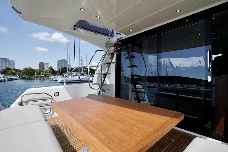  Yacht Photos Pics Prestige 460 yacht deck with wooden table, marina view, and modern design, 2023 model.