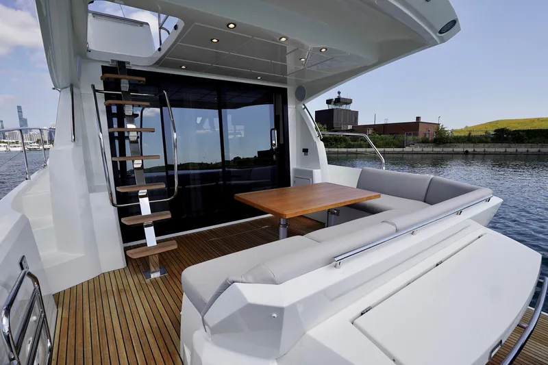  Yacht Photos Pics 2023 Prestige 460 yacht deck with seating, table, and modern staircase.