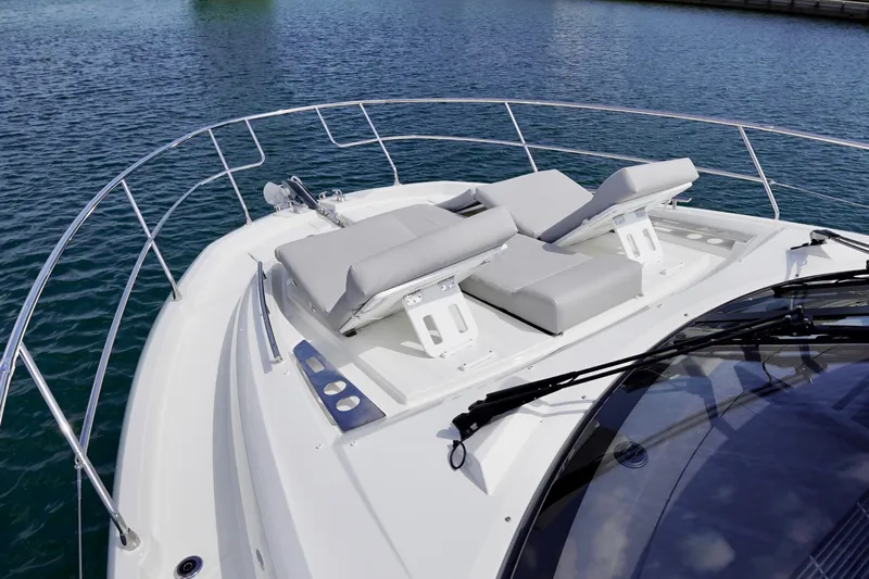  Yacht Photos Pics Prestige 460 yacht 2023 model with sun loungers on deck, surrounded by water.