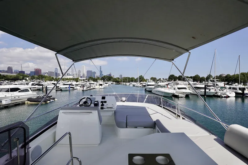  Yacht Photos Pics 2023 Prestige 460 yacht docked in a marina with city skyline in the background.