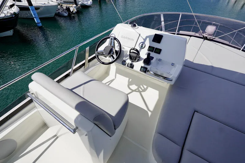  Yacht Photos Pics Flybridge of 2023 Prestige 460 yacht with helm station and seating, docked in marina.