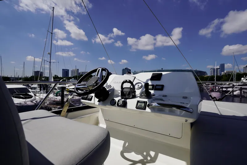  Yacht Photos Pics Helm of 2023 Prestige 460 yacht with city skyline and marina backdrop.