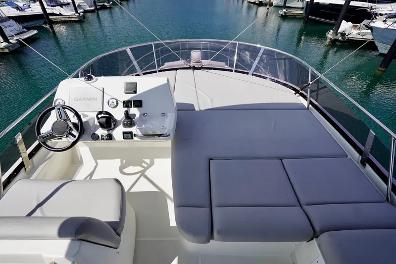  Yacht Photos Pics Flybridge of 2023 Prestige 460 yacht with helm and sunbathing area, docked in marina.