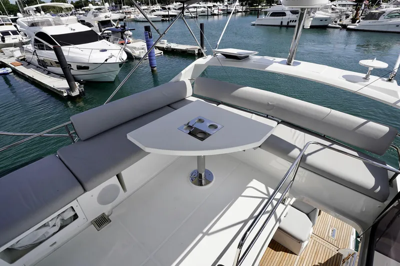  Yacht Photos Pics Luxurious 2023 Prestige 460 yacht interior with seating and table, docked at marina.