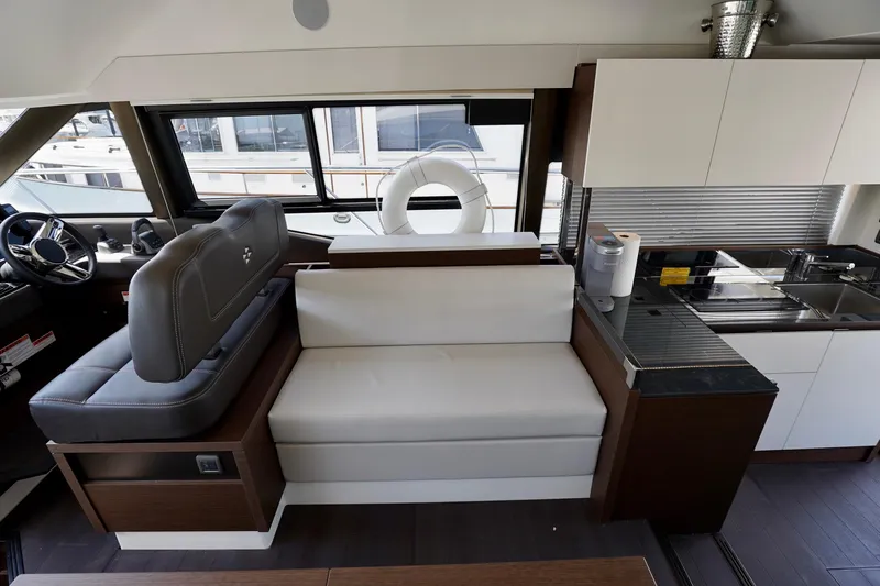  Yacht Photos Pics Interior of a 2023 Prestige 460 yacht featuring modern seating and kitchen area.