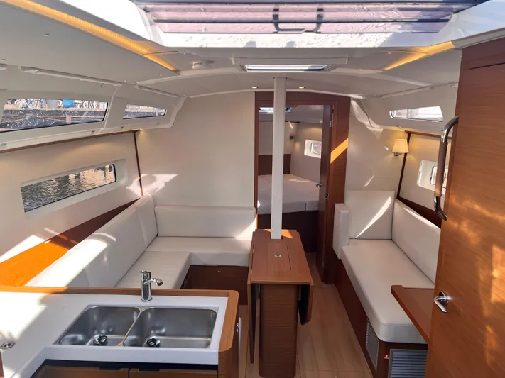  Yacht Photos Pics Luxurious interior of 2024 Jeanneau 380 yacht with modern seating and kitchen area.