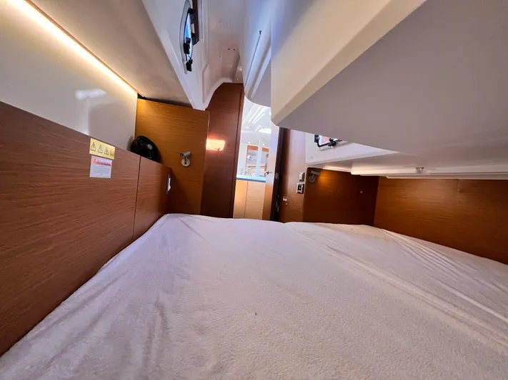  Yacht Photos Pics 2024 Jeanneau 380 interior cabin with wood paneling and cozy bedding.