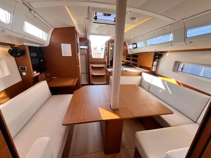  Yacht Photos Pics 2024 Jeanneau 380 interior with modern wood finish and spacious seating area.