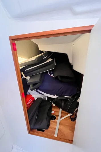  Yacht Photos Pics Storage compartment in a 2024 Jeanneau 380 sailboat, filled with cushions and gear.