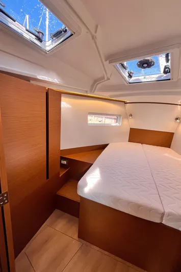  Yacht Photos Pics 2024 Jeanneau 380 cabin interior with skylights, wooden finish, and comfortable bedding.
