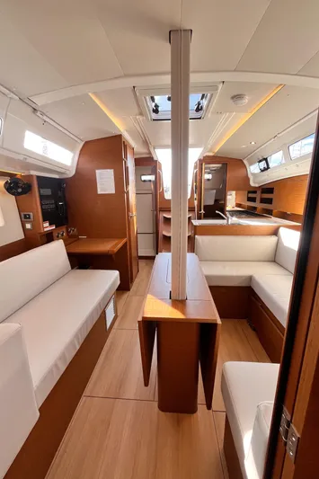  Yacht Photos Pics 2024 Jeanneau 380 yacht interior with modern wood finish and white seating.