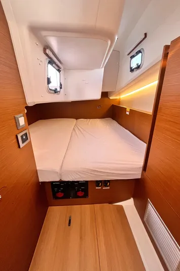  Yacht Photos Pics 2024 Jeanneau 380 cabin interior with cozy bed and wooden finish.